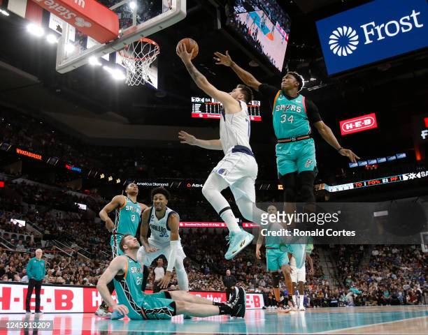 Luka Doncic of the Dallas Mavericks drives past Stanley Johnson of the San Antonio Spurs in the second half at AT&T Center on December 31, 2022 in...