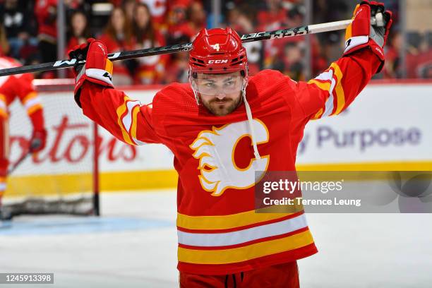 Rasmus Andersson of the Calgary Flames stretches during warm-up prior to the game against the Vancouver Canucks at Scotiabank Saddledome on December...
