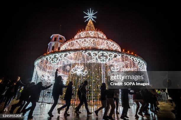 People dance around the Christmas tree at the Cathedral square in Vilnius during the New Year celebration.