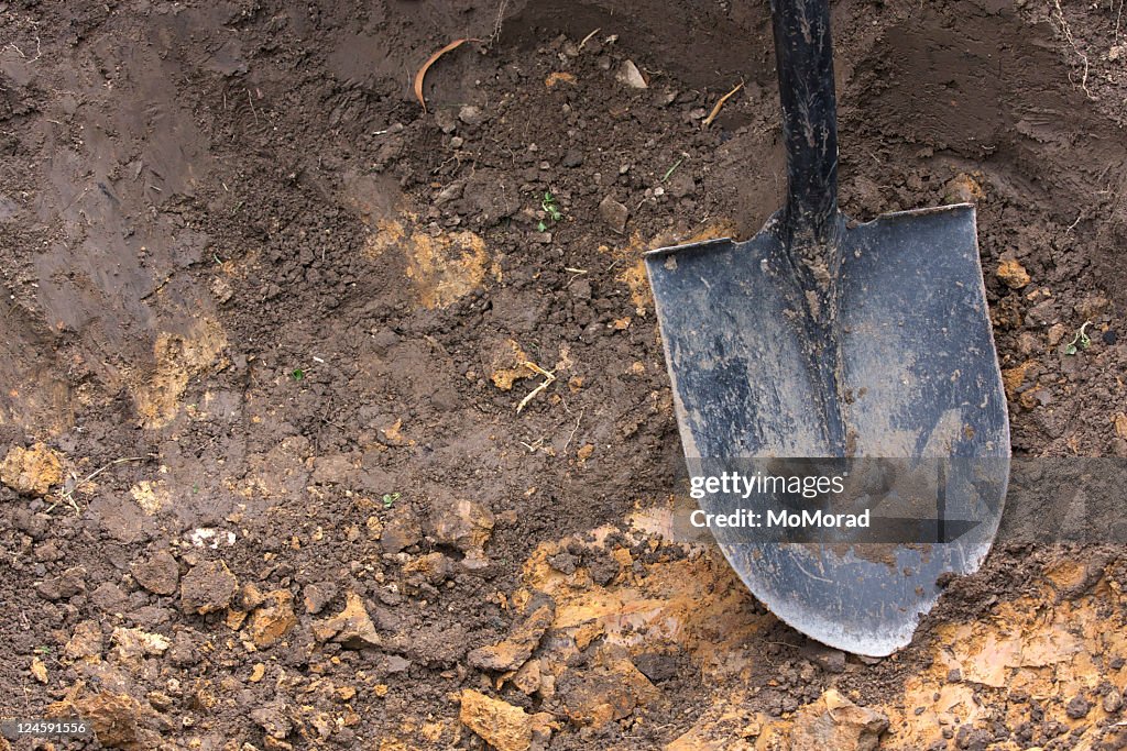 Close-up of spade shovel being used to dig a hole in soil