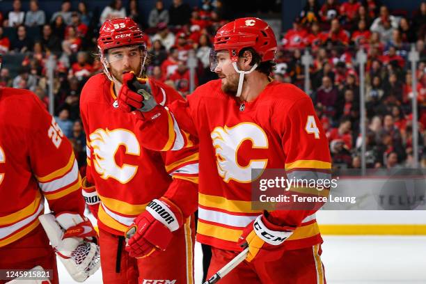 Rasmus Andersson and Noah Hanifin of the Calgary Flames chate between whistles against the Calgary Flames at Scotiabank Saddledome on December 31,...