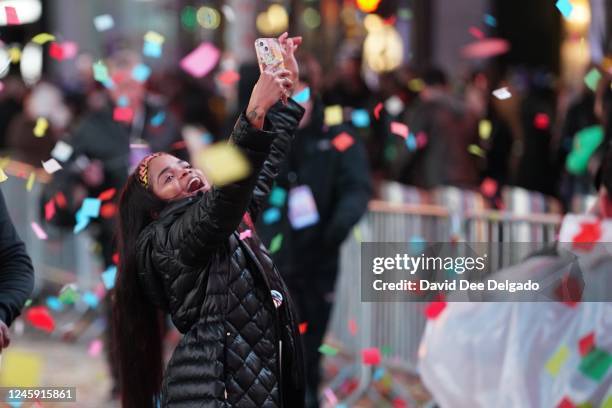 Reveler catches confetti during the new year celebrations at Times Square on January 1, 2023 in New York City. People began celebrating New Year's...