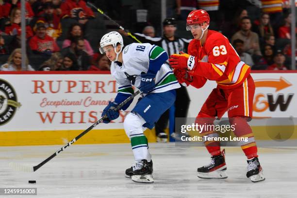 Adam Ruzicka of the Calgary Flames battles against Jack Studnicka of the Vancouver Canucks at Scotiabank Saddledome on December 31, 2022 in Calgary,...