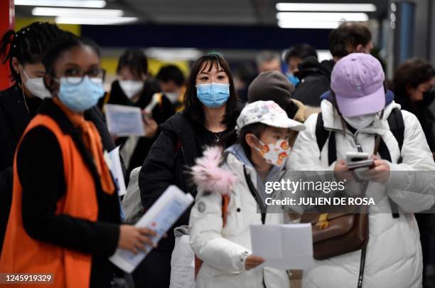 Passengers of a flight from China wait in a line for checking their COVID-19 vaccination documents as a preventive measure against the Covid-19...