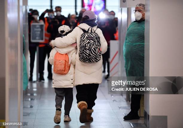 Passengers of a flight from China walks through the COVID-19 testing booths at the Paris-Charles-de-Gaulle airport in Roissy, outside Paris, on...
