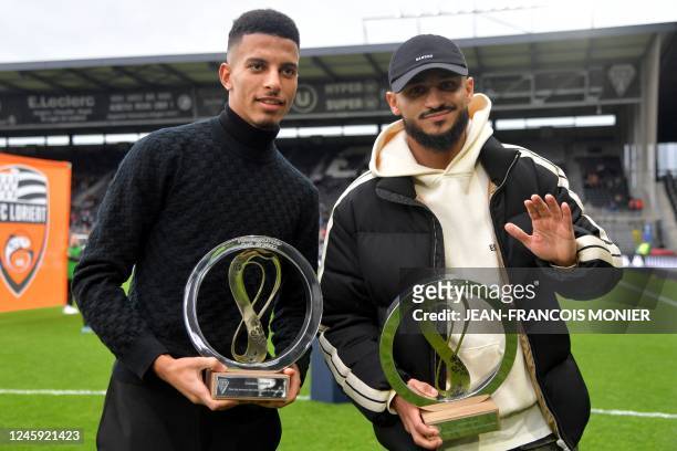 Angers' Moroccan players Azzedine Ounahi and Sofiane Boufal pose with their Qatar 2022 World Cup trophies prior to the French L1 football match...