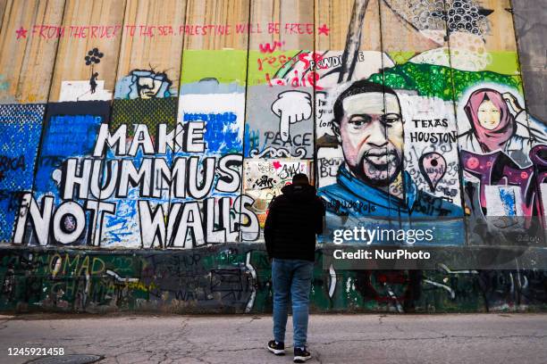 'Make Hummus Not Walls' street art graffiti and George Floyd's poitrait are seen on the Israeli separation West Bank Wall in Bethlehem, Palestine on...