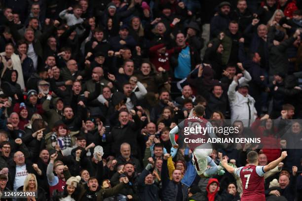 Aston Villa's Argentinian midfielder Emiliano Buendia celebrates in front of the Villa fans after scoring the opening goal of the English Premier...