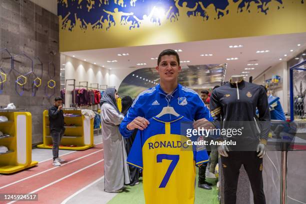Man poses for a photo with Ronaldo's number 7 jersey after Portuguese professional footballer Ronaldo's transfer as a forward for Al Nassr in Riyadh,...