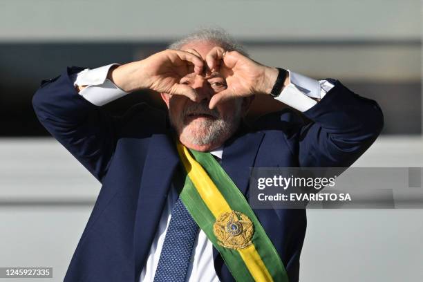Brazil's new President Luiz Inacio Lula da Silva gestures at supporters making a heart sign with his hands at Planalto Palace after their...