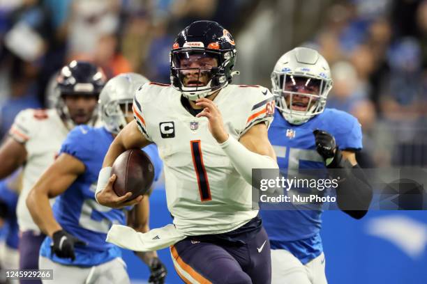 Chicago Bears quarterback Justin Fields carries the ball under the pressure of Detroit Lions defense during an NFL football game between the Detroit...