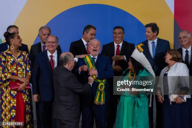 Luiz Inacio Lula da Silva, Brazil's president, center, fixes the presidential sash during official photograph with newly appointed ministers after...