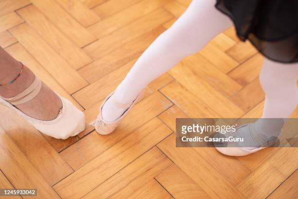 hoge hoekmening van de voeten van de moeder en van de dochter in balletschoenen die naar elkaar richten - voorraadfoto - ballerina feet stockfoto's en -beelden