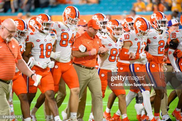 Clemson head coach Dabo Swinney link arms with Clemson tight end Davis Allen and Clemson wide receiver Drew Swinney along with Clemson quarterback...