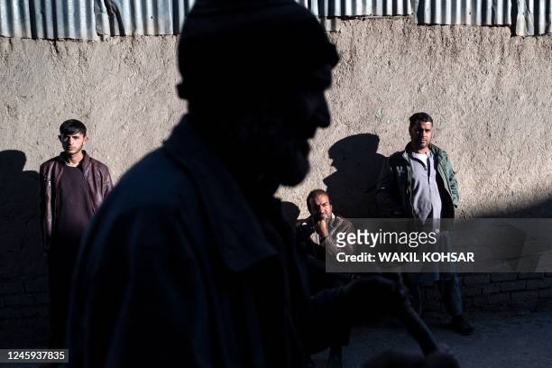 Afghan men gesture along a street in Kabul on January 2, 2023.
