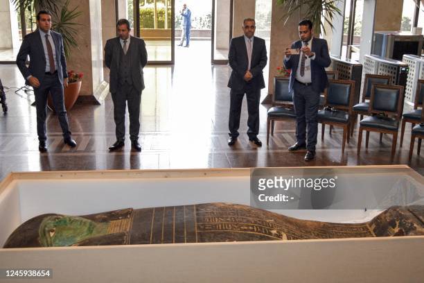 This picture taken on January 2, 2023 shows a view of an ancient Egyptian wooden sarcophagus being handed over and which was formerly displayed at...