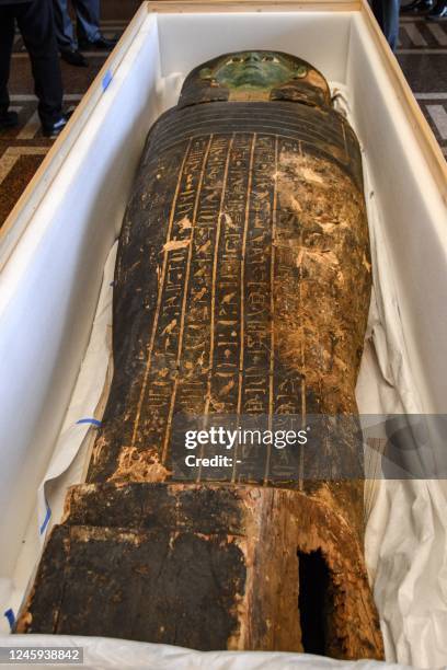 This picture taken on January 2, 2023 shows a view of an ancient Egyptian wooden sarcophagus being handed over and which was formerly displayed at...