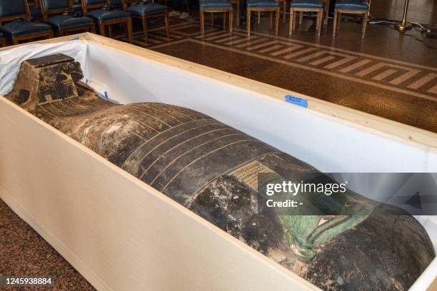 This picture taken on January 2, 2023 shows a view of an ancient Egyptian wooden sarcophagus being handed over and which was formerly displayed at...