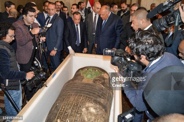Egypt's Foreign Minister Sameh Shoukry and the head of the Supreme Council of Antiquities Mostafa Waziri are surrounded by journalists as they...
