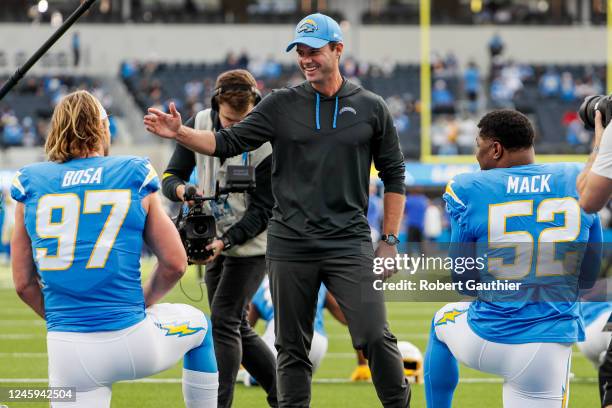 Inglewood, CA, Sunday, January 1, 2022 - Chargers coach Brandon Staley smiles as he greets Joey Bosa, left and Khalil Mack during warmups before...