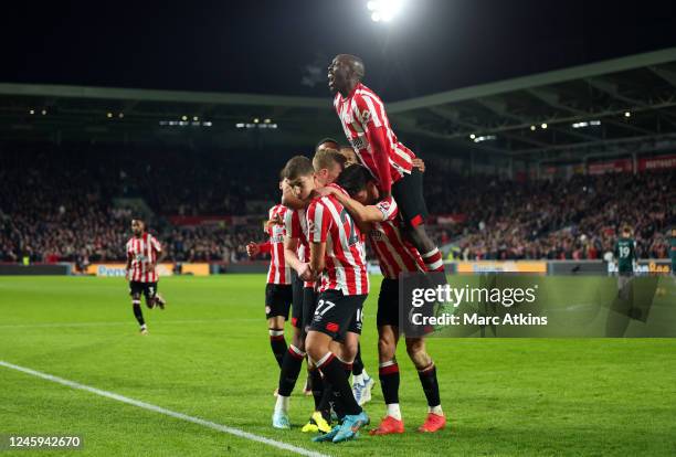 Ben Mee of Brentford celebrates scoring the first goal with team mates during the Premier League match between Brentford FC and Liverpool FC at...