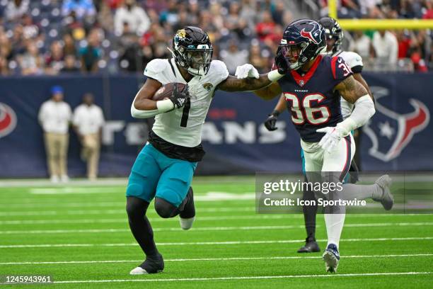 Jacksonville Jaguars running back Travis Etienne Jr. Stiff arms Houston Texans safety Jonathan Owens at the end of a first half running play during...