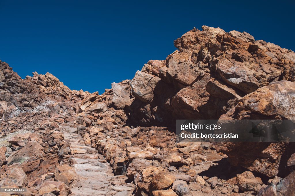 Low Angle View Of Rock Formation Against Clear Blue Sky