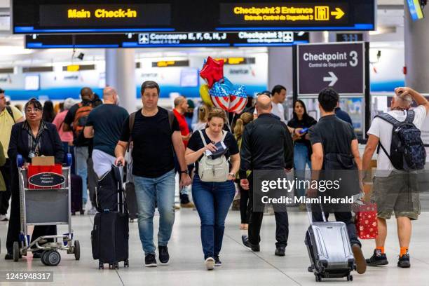 On Wednesday, Nov. 23 travelers walk the halls at the departures level inside Miami International Airport in Miami.