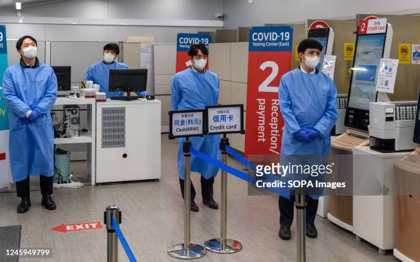 Quarantine officials seen preparing for a PCR test for travelers arriving from China in COVID-19 testing station at Incheon International Airport,...