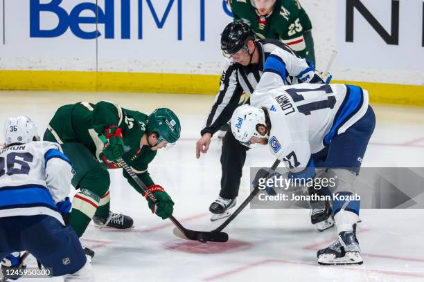 Sam Steel of the Minnesota Wild and Adam Lowry of the Winnipeg Jets take a third period face-off at Canada Life Centre on December 27, 2022 in...