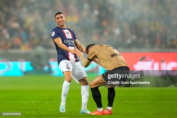 Achraf Hakimi helps Florian Sotoca during the French Ligue 1 match between RC Lens and Paris Saint-Germain at Stade Bollaert on January 1, 2023 in...