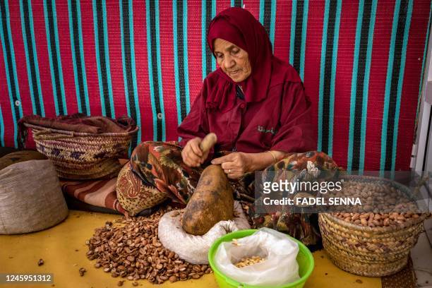 Woman shells Argan nuts to make oil near Morocco's western Atlantic coastal city of Essaouira, on October 15, 2022. - Morocco's argan oil is highly...
