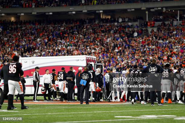 Buffalo Bills and Cincinnati Bengals players react to an injury sustained by Damar Hamlin of the Buffalo Bills during the first quarter of an NFL...