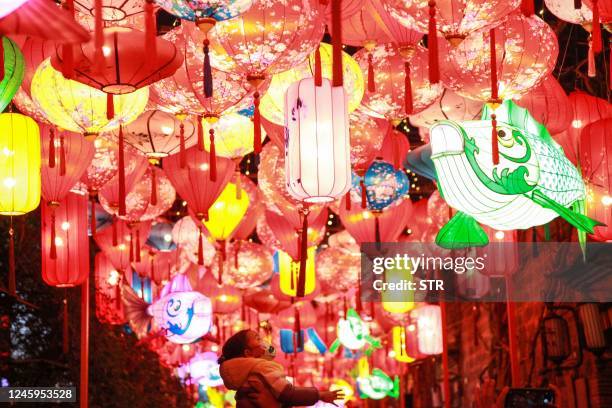 This photo taken on January 2, 2023 shows a child looking at lanterns in Nanjing, in China's eastern Jiangsu province. - China OUT / China OUT