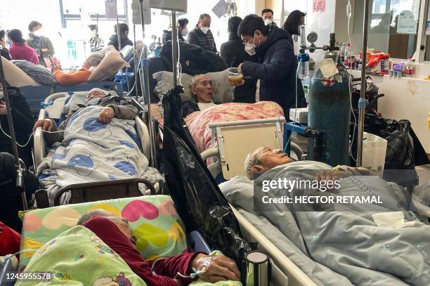 Patients on stretchers are seen at Tongren hospital in Shanghai on January 3, 2023. - A senior doctor at Shanghai's Ruijin Hospital has said 70...