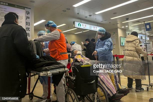Health worker speaks with a patient on a wheelchair in the emergency department of a hospital in Beijing on January 3, 2023. - Cities across China...