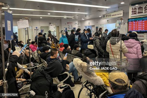 This picture shows patients on wheelchairs and people in the emergency department of a hospital in Beijing on January 3, 2023. - Cities across China...