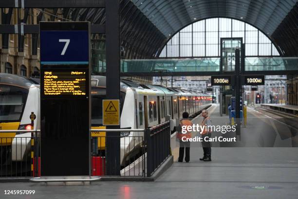 Station staff wait by a train at King's Cross Station during a strike by the Rail, Maritime and Transport Workers union on January 3, 2023 in London,...