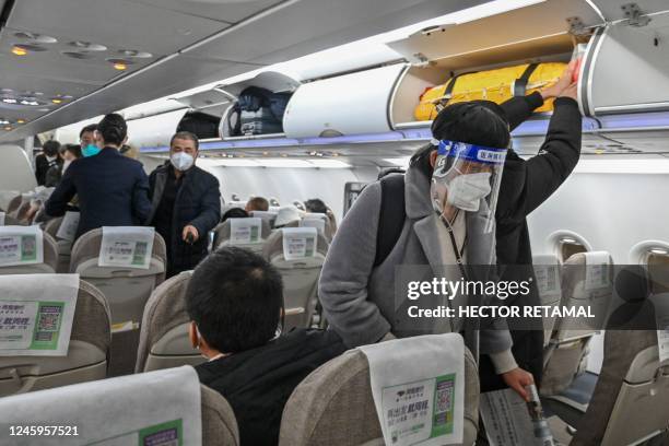 Passenger wearing a face shield and mask amid the Covid-19 pandemic boards a domestic flight at Shanghai Pudong International Airport in Shanghai on...