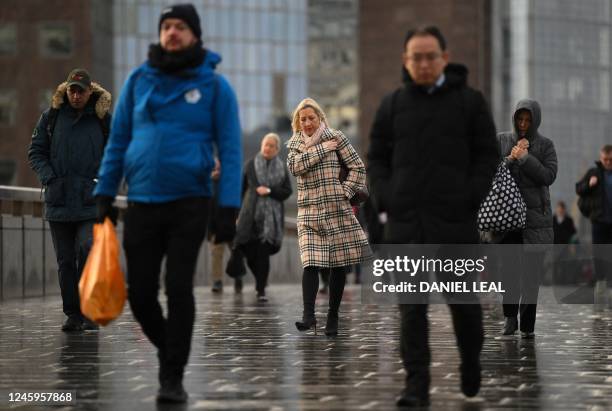 Commuters on their way to work cross London Bridge in central London on January 3, 2023. - UK rail staff disrupted the New Year return to work in the...