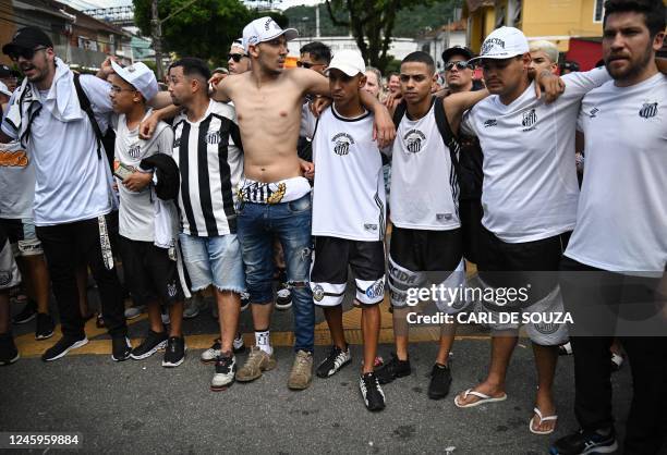 Fans of the late Brazilian football star Pele gather on the street as a firetruck transports Pele's coffin to the Santos' Memorial Cemetery in...