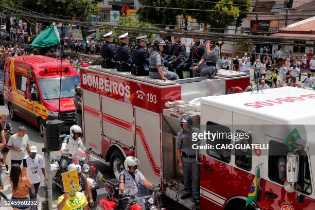 Fans of the late Brazilian football star Pele gather on the street as a firetruck transports Pele's coffin to the Santos' Memorial Cemetery in...