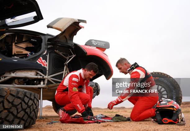 French driver Sebastien Loeb and Belgian co-driver Fabian Lurquin change tyres after the Stage 3 of the Dakar 2023 rally between al-Ula and Hail got...