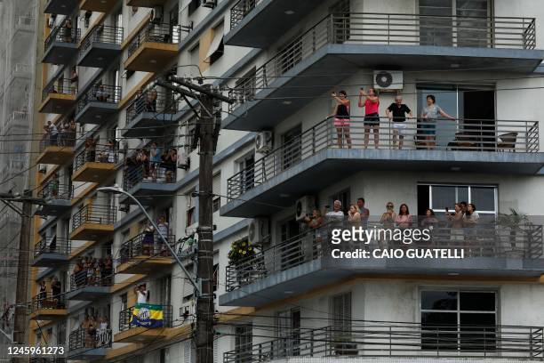 Fans of the late Brazilian football star Pele observe from balconies as a firetruck transports Pele's coffin to the Santos' Memorial Cemetery in...