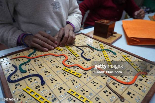 Visually impaired students play snakes and ladder board game in Braille- a tactile writing system at a school run by the Blind Relief Association...