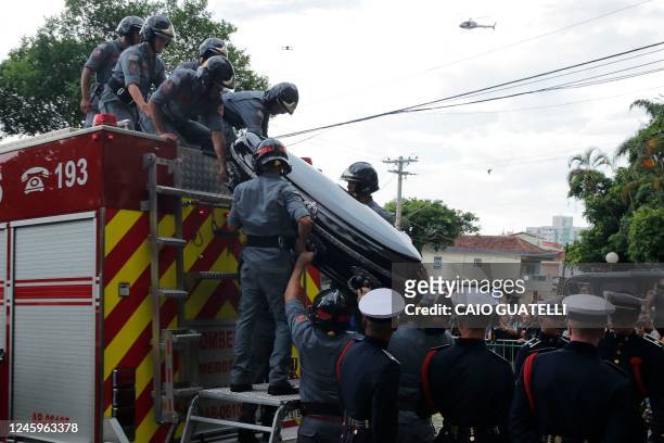 The coffin of the late Brazilian football star Pele is transported to the Santos' Memorial Cemetery after the funeral procession in Santos, Sao Paulo...