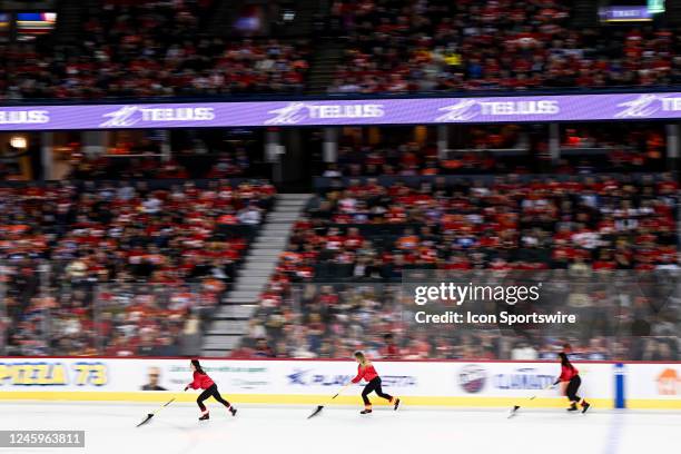 Calgary Flames ice girls clean the ice during the first period of an NHL game between the Calgary Flames and the Edmonton Oilers on December 27 at...