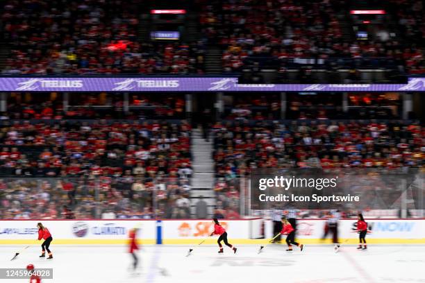 Calgary Flames ice girls clean the ice during the first period of an NHL game between the Calgary Flames and the Edmonton Oilers on December 27 at...