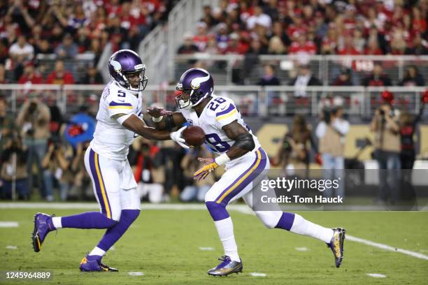 Minnesota Vikings running back Adrian Peterson takes off from line and receives ball from teammate Minnesota Vikings quarterback Teddy Bridgewater...