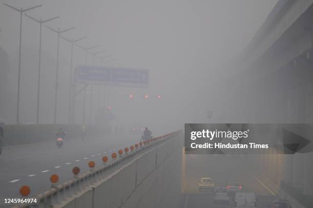 People going to their workplace wearing warm clothes amid cold and dense foggy weather at Golf Course Road near DLF phase-1, on January 2, 2022 in...